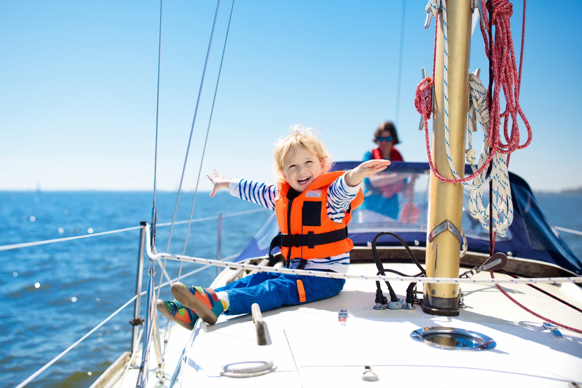 kind met reddingsvest op zeiljacht op zee